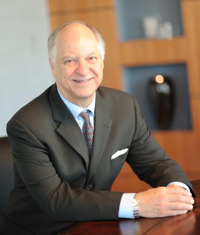 Gordon R. Bernard, M.D., Director, sitting at a table and smiling in a professional office environment.