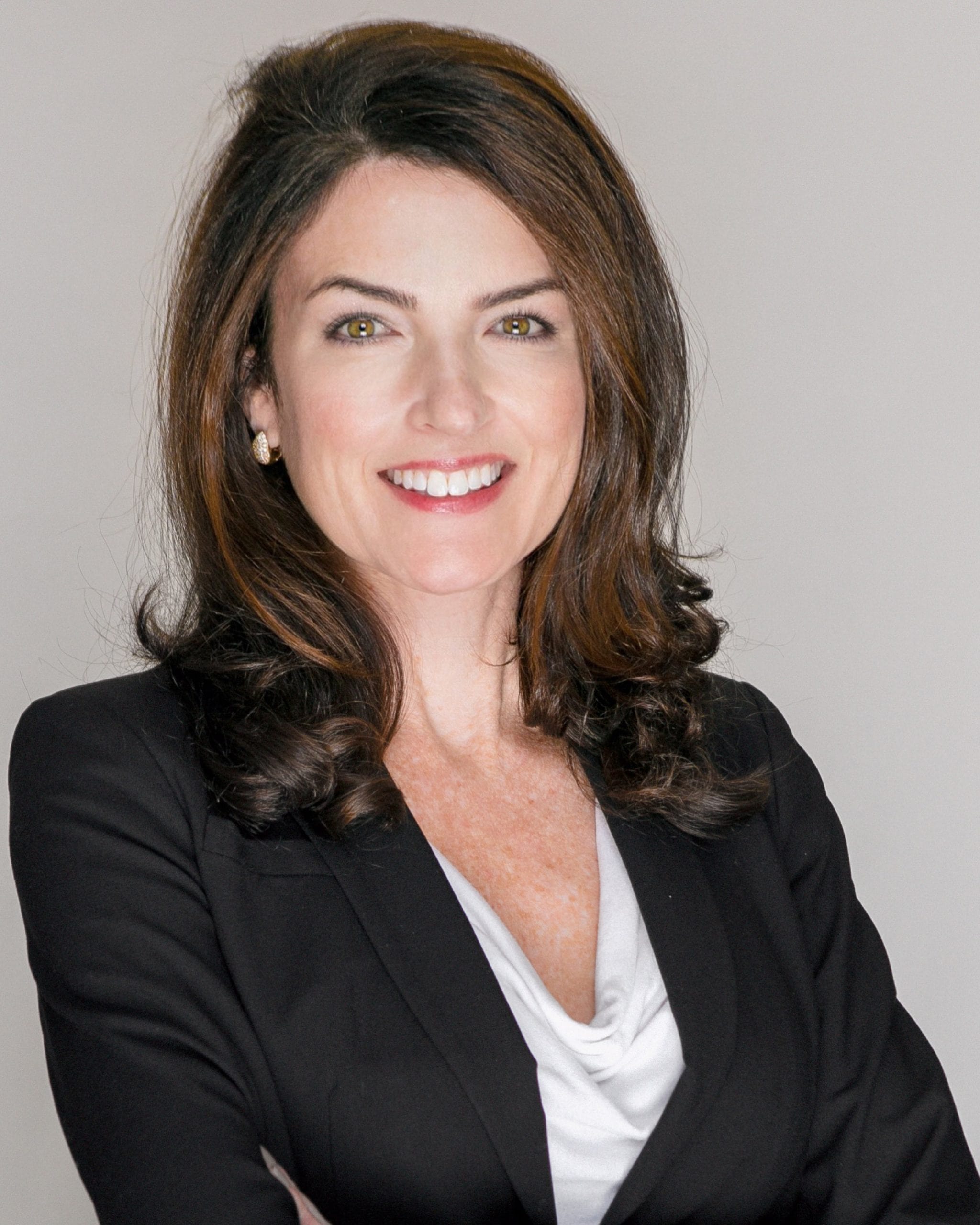 Caroline R. Young, Director, smiling with arms crossed, wearing a professional suit.