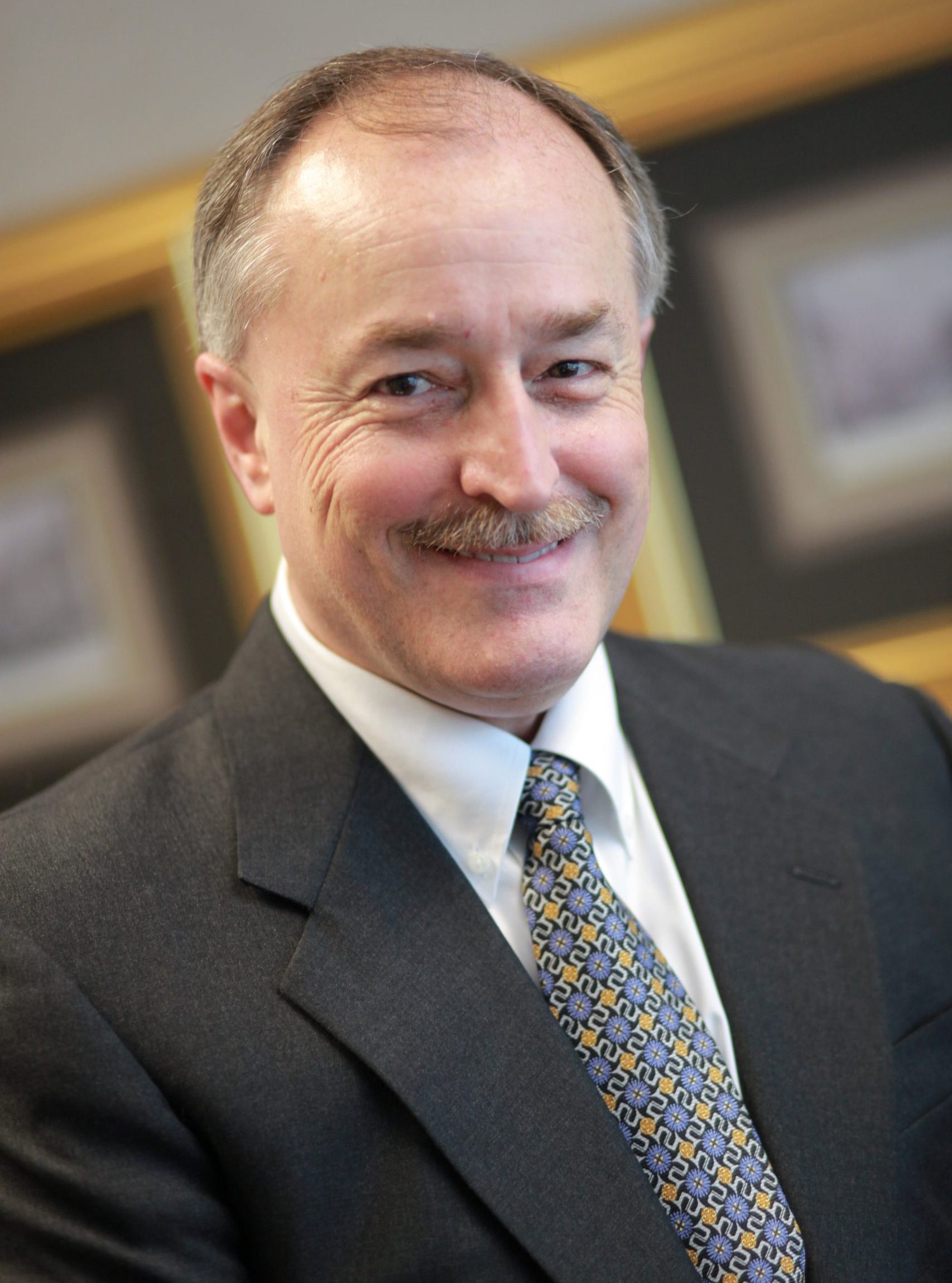 James Herman, National Accounts and Chief Compliance Officer, smiling in a suit and patterned tie.