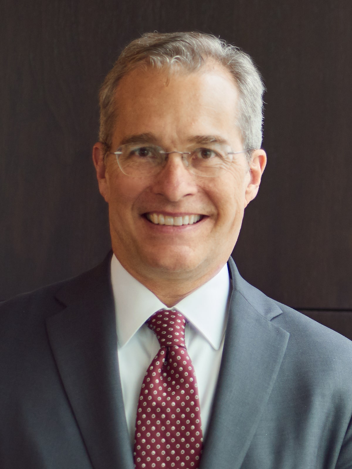 Martin S. Brown, Director, smiling in a suit and patterned tie.